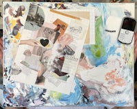 a person holding up a piece of art with a cell phone